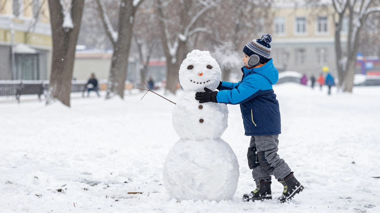 Ребенок лепит снеговика в правильной трехслойной зимней одежде на морозе.